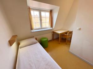 吕贝克吕贝克老城青年旅舍的小房间设有床、桌子和窗户