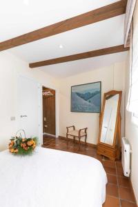 博伊罗Casa Costaneira的卧室配有白色的床和镜子