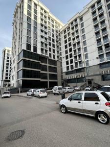 撒马尔罕Apartment for tourists的大型建筑前设有停车场,可停放汽车