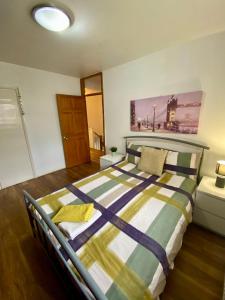 伦敦3 Bedroom House-Garden-Stratford-Olympic Park的一间卧室配有带条纹被子的床