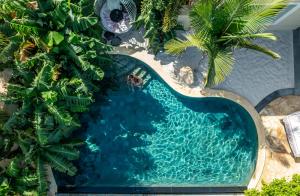 阿德耶Royal River, Luxury Hotel - Adults Only的享有棕榈树游泳池的顶部景致
