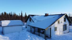 基律纳Arctic Cottage Kiruna, Groups的屋顶上积雪的房子