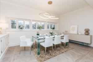 BuckinghamshireWisteria House - Sleeps 11的白色的用餐室配有桌子和白色的椅子