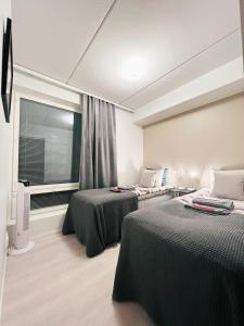 库奥皮奥Apartment near the train station, free parking &Netflix的酒店客房设有两张床和窗户。
