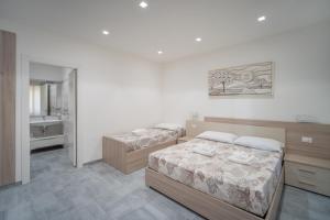 斯卡莱阿Vincent B&B - vicini al mare的一间带两张床的卧室和一间浴室