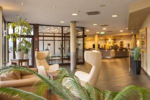 伯格奥夫费马恩费马恩岛IFA假日酒店的大堂,在大楼内摆放着白色椅子和植物