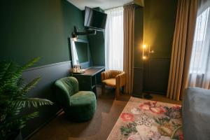 海尔伦Stadshotel Heerlen的客厅配有椅子和墙上的电视
