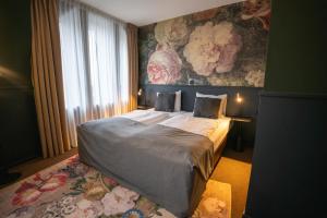 海尔伦Stadshotel Heerlen的一间卧室设有一张带花卉墙壁的大床