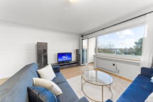鲁尔河畔米尔海姆VINFUL: Premium-Apartment mit Balkon und Parkplatz的客厅配有蓝色的沙发和电视