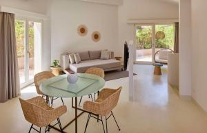 奇亚Baia Di Chia Resort Sardinia, Curio Collection By Hilton的客厅配有桌椅和沙发