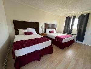 北山北山家乡旅馆的酒店客房,配有两张带红色床单的床