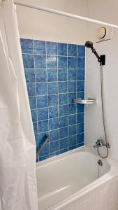 科隆Ferienwohnungen in Köln 0904的带浴缸的浴室和蓝色瓷砖墙
