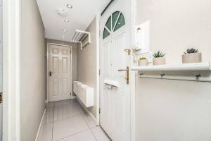 伦敦Pass the Keys Whitechapel Central Apartment的浴室设有白色门和白色瓷砖地板。