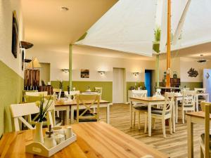 洛布Strandhaus Mönchgut Bed & Breakfast Lobbe的配有木桌和白色椅子的餐厅