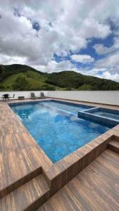 圣阿马鲁-达因佩拉特里斯Sítio com piscina incrível的一座带木甲板的建筑的顶部游泳池