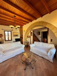 罗德镇Suite del Capitano的客厅配有2张白色的床和桌子