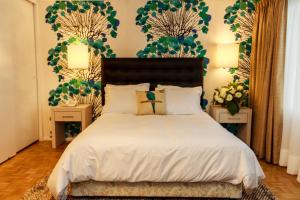 康塞普西翁HOTEL ALONSO DE ERCILLA的一间卧室配有一张带白色床单和绿色壁纸的床。