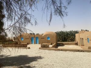 Al QaşrBeir El Gabal Hotel (with Hot Springs)的沙漠中带蓝色门的家