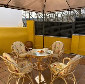 HoyocaseroCasa Rural El Encanto de Gredos的庭院配有桌椅和遮阳伞。