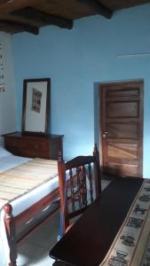 胡阿卡勒拉La Casita de la Abuela Huacalera - Quebrada de Humahuaca的一间卧室配有一张床、一张桌子和一扇木门