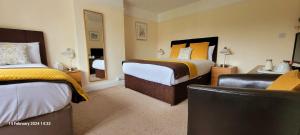 埃文河畔斯特拉特福Hampton Lodge En-Suite Rooms with Free Parking的酒店客房,配有两张床和椅子