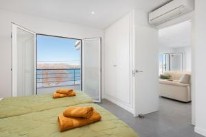 阿尔库迪亚S'Embat sea views的一间卧室设有两张床和大窗户