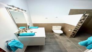 科斯塔卡玛Maya Powered by SolymarCalma的一间带卫生间、水槽和镜子的浴室