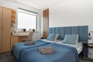 波兹南Sapphire Room Hotel Lechicka的一间卧室配有两张蓝色床单