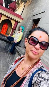 瑞诗凯诗Rishikesh Shiv Dham Homestay的站在建筑物前戴太阳镜的女人