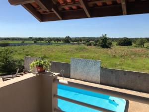 巴拉-杜加萨斯Pousada Encantos do Roncador的游泳池位于享有田野美景的阳台上