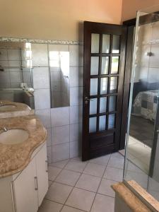 巴拉-杜加萨斯Pousada Encantos do Roncador的一间带水槽和玻璃门的浴室