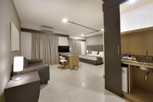 里贝朗普雷托艾罗克里亚广场酒店的酒店客房设有床和客厅。