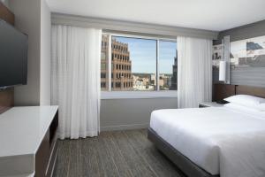 堪萨斯城万豪乡村俱乐部酒店的酒店客房设有一张床和一个大窗户