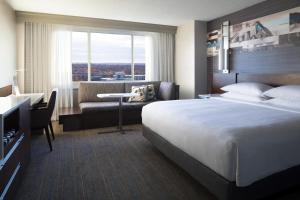 堪萨斯城万豪乡村俱乐部酒店的酒店客房设有一张大床和一张书桌。