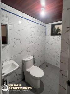 圣费尔南多Hilda’s Apartments的白色的浴室设有卫生间和水槽。