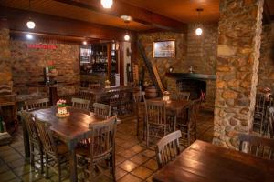 特里温福Pousada Baixa Verde的餐厅设有木桌、椅子和壁炉