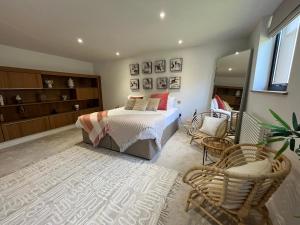 卡迪夫Beachcliff Rooms & Apartments的一间卧室配有一张床和一把椅子