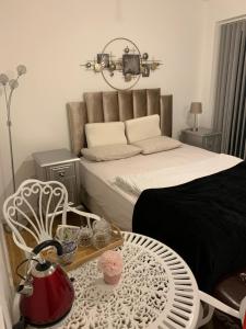哈洛Countryside Luxury House Harlow的卧室配有一张床和一张桌子及椅子