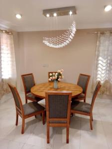 阿克拉Cozy home in East Legon Hills的一间带木桌和椅子的用餐室