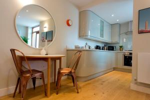 伦敦Madison Hill - Byrne Garden 2 - One bedroom home的厨房配有桌椅和镜子