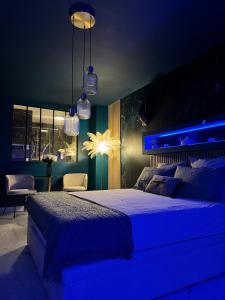 滨海拉塞讷Flower Suite and Spa的一间卧室配有一张蓝色灯光的大床