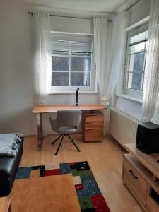 格拉茨Wohnen in Graz Mariatrost的窗户客房内的一张桌子和一把椅子