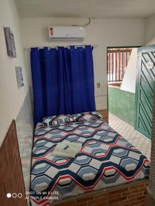 加利纽斯Pousada Galinhos的一间卧室配有一张蓝色窗帘的床
