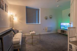 伯明翰1 Bedroom Apartment - Netflix - Close To City Centre And NEC的带沙发、桌子和电视的客厅