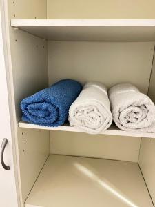 赫尔辛基Private rooms near metro, free parking的衣柜架上的三条毛巾