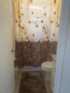 Old HarbourMJ Manor的浴室设有贝壳淋浴帘和卫生间。