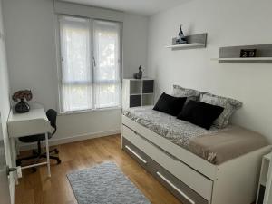 奥利奥Apartamento moderno y acogedor ideal familias的一间卧室配有一张床、一张书桌和一个窗户。