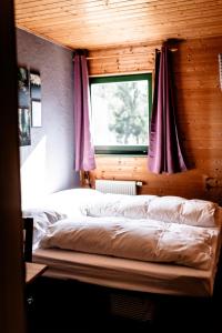 heimatbude.的一间卧室配有一张带窗户和紫色窗帘的床