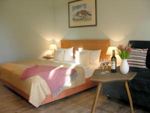 克洛斯特Hotel Enddorn Hiddensee的酒店客房,配有床和桌子,配以酒杯