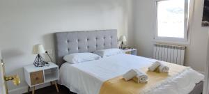 蒙达卡Mundaka Sea Flat的卧室配有一张带2条毛巾的大型白色床
